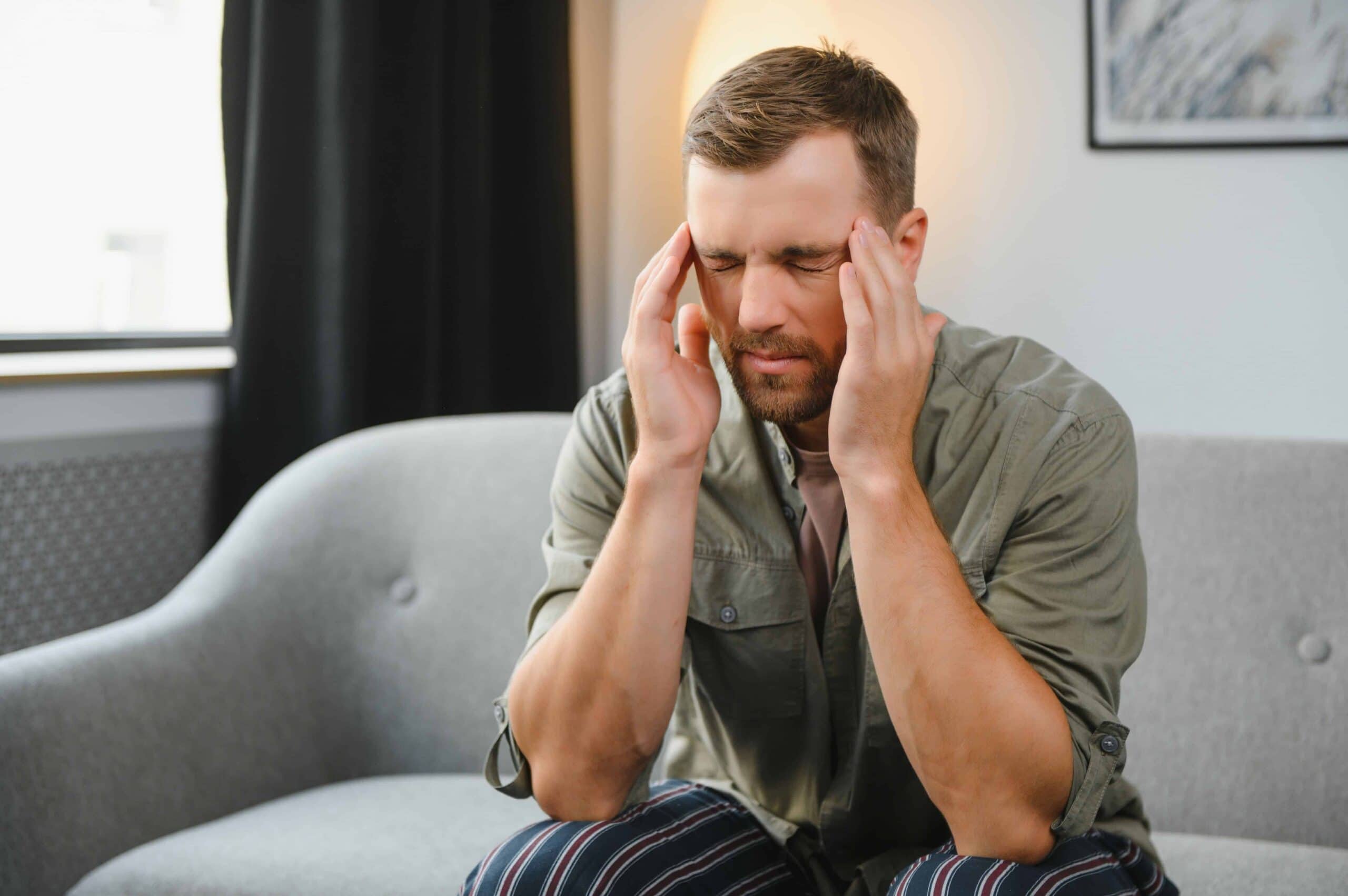 Man holding his head asking if does alcohol tolerance go down​.